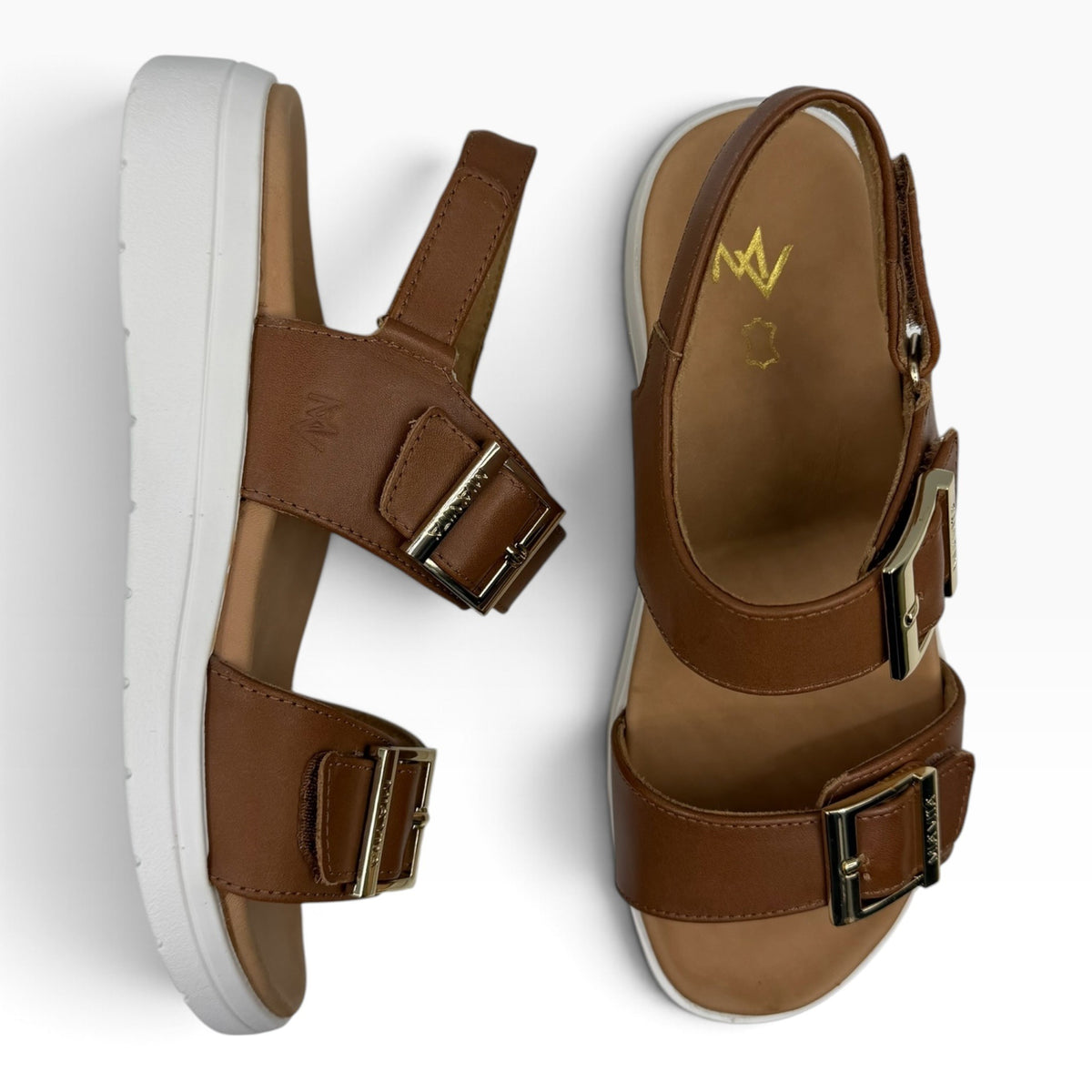 The Shoe Shop Bettina sandal in tan leather with double gold buckles and a white platform sole.