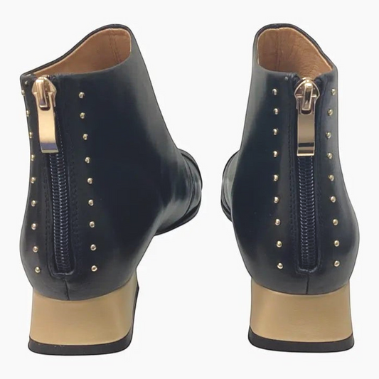 The Shoe Shop Bresley Demon black leather ankle boots featuring rear zip closures, gold block heels, and metal studs.