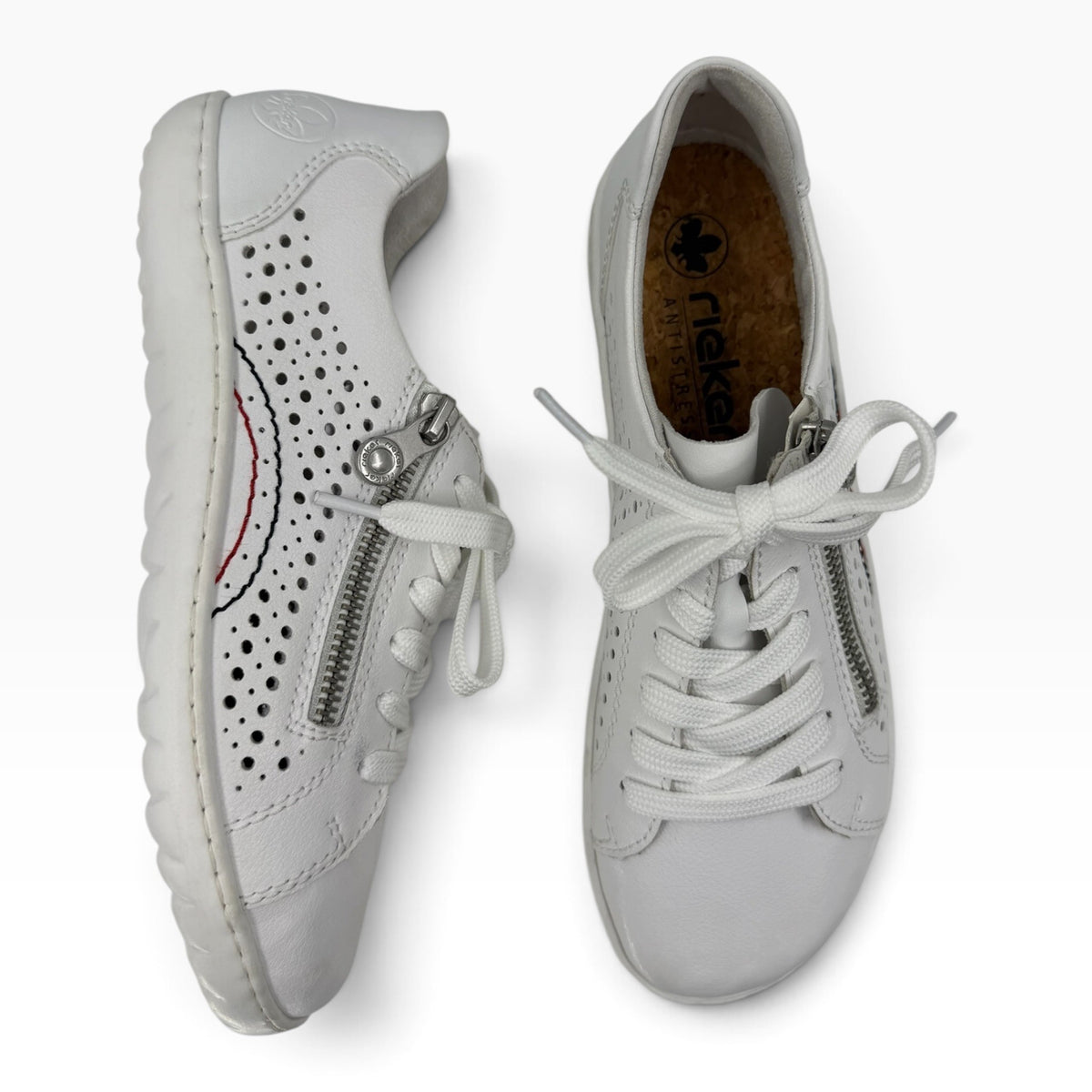 The Shoe Shop Dana white leather sneakers featuring laser-cut perforations, lace-up closure, and side zip detail.