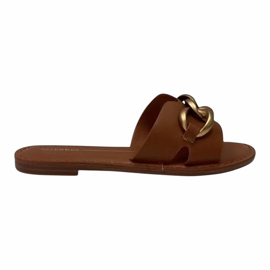 The Shoe Shop Maiz tan flat slide sandals featuring a smooth upper and a chunky gold-tone chain detail.