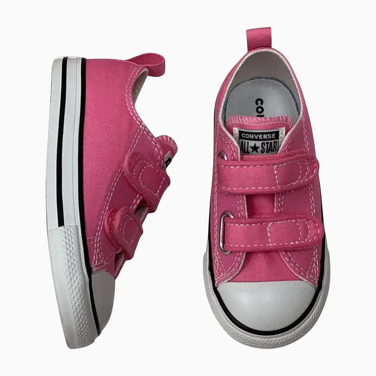 The Shoe Shop pink canvas infant Chuck Taylor All Star low-top sneakers with two hook-and-loop straps.