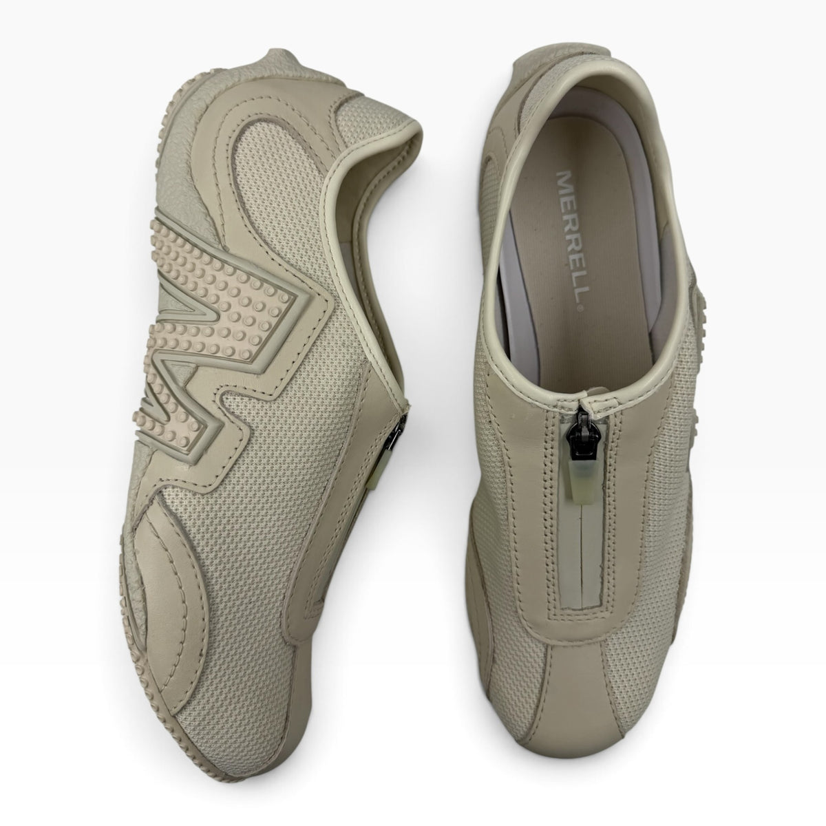 The Shoe Shop Relay Fly Zip sneakers in stucco beige featuring a mesh upper, front zipper closure, and rubber details.