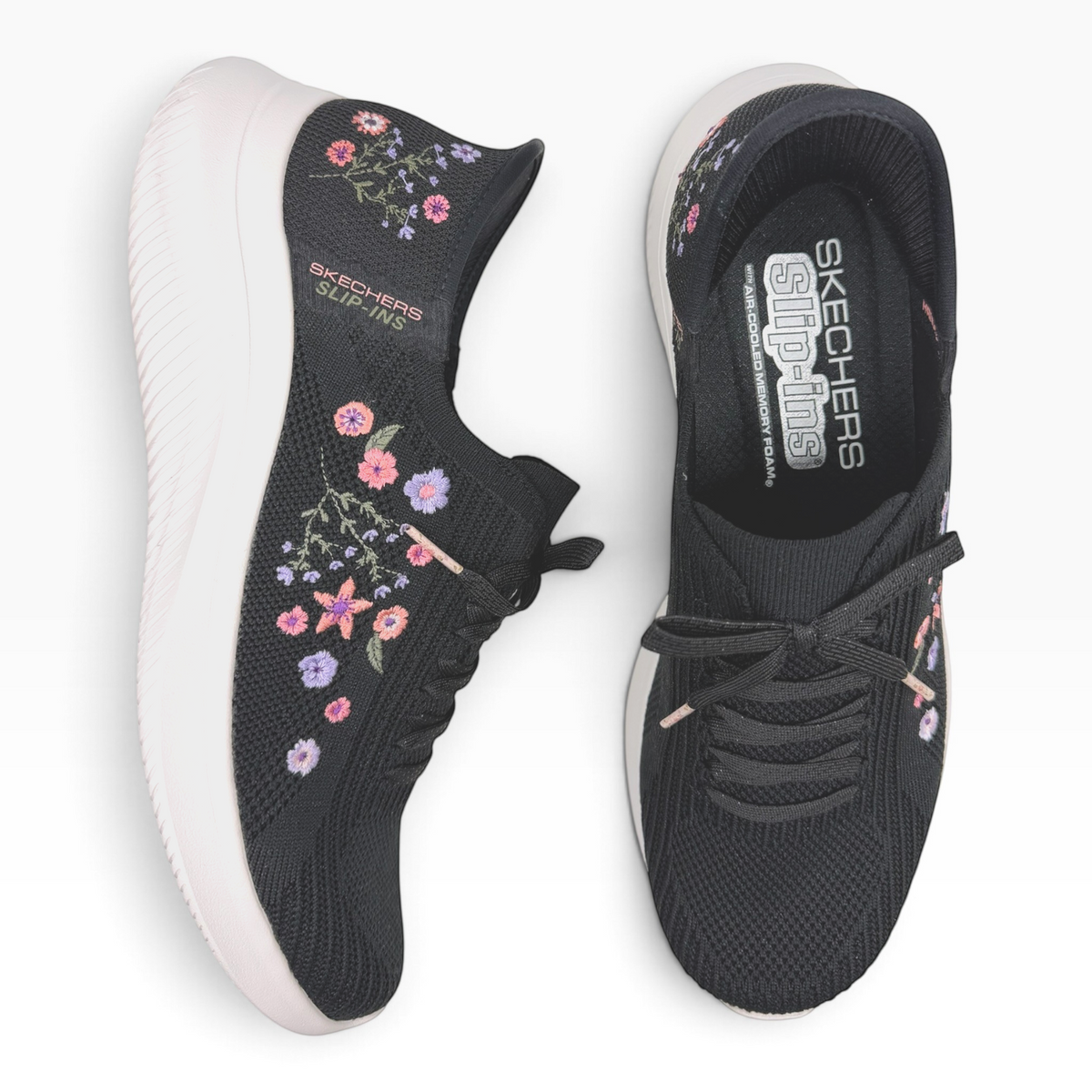The Shoe Shop Skechers Ultra Flex 4.0 black slip-on sneakers with floral embroidery and white cushioned soles.