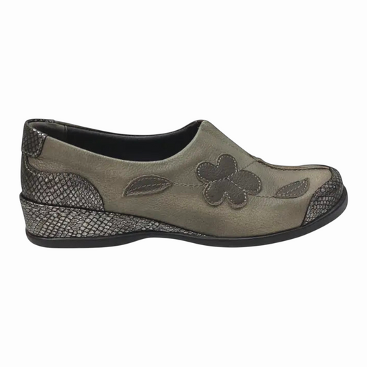 The Shoe Shop Adeline slip-on shoe in grey leather with a decorative flower, metallic accents, and a low wedge heel.