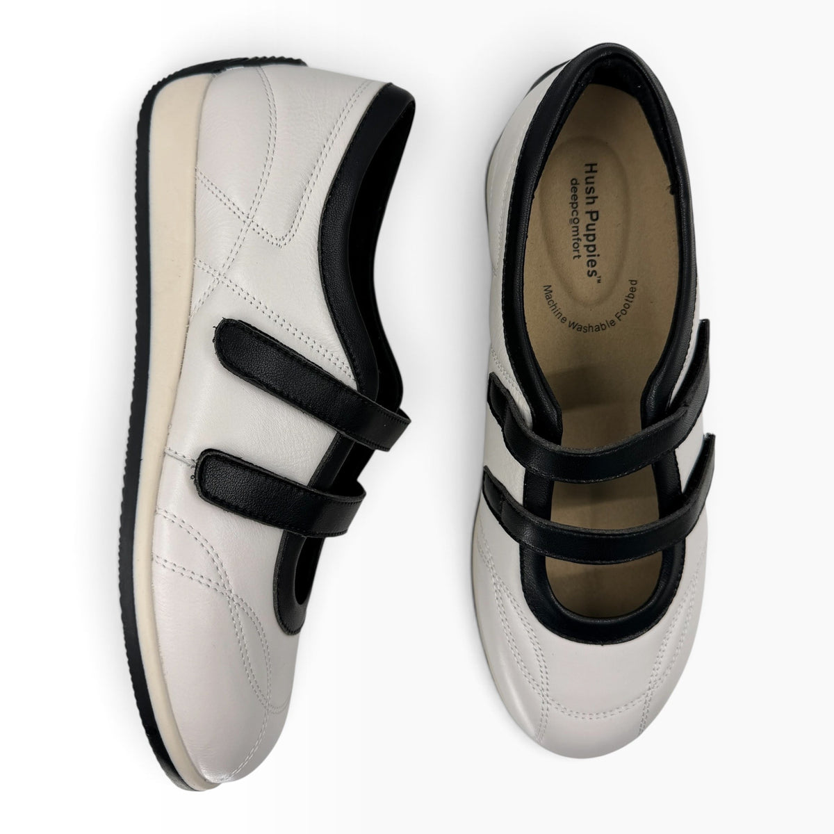 The Shoe Shop Amor flat in white and black leather with twin adjustable hook-and-loop straps and a rubber sole.