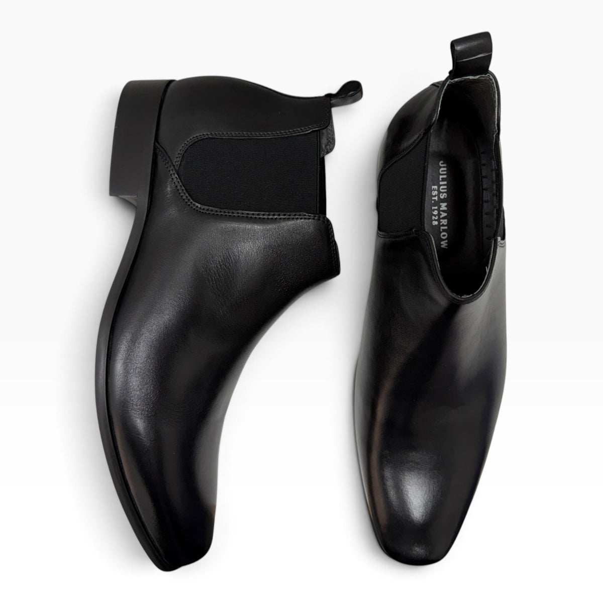 The Shoe Shop Julius Marlow black leather Chelsea boots with elastic gussets and heel pull tabs, top-down view.