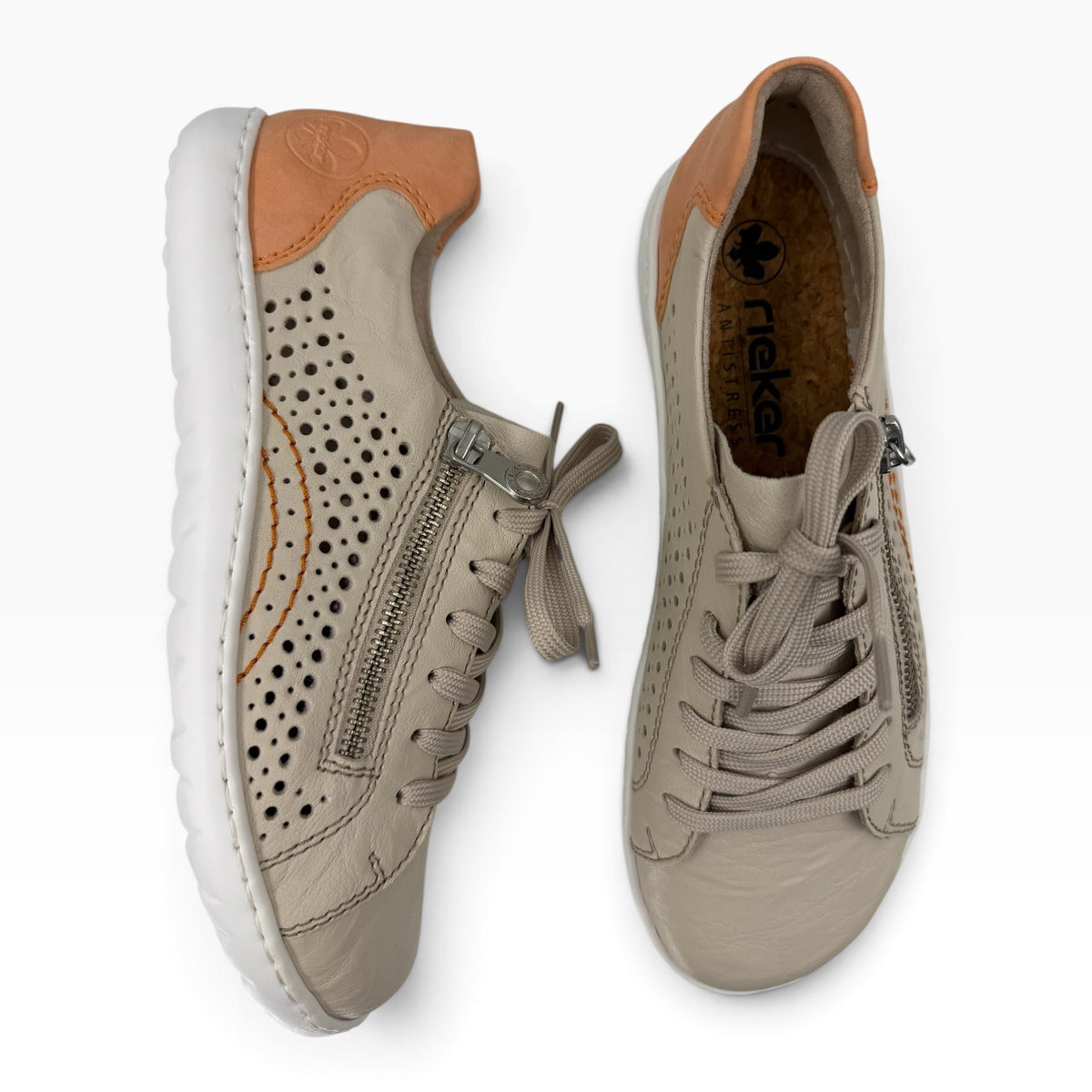 The Shoe Shop Dana leather sneakers in beige with laser-cut perforations, side zip, and tan heel detail.