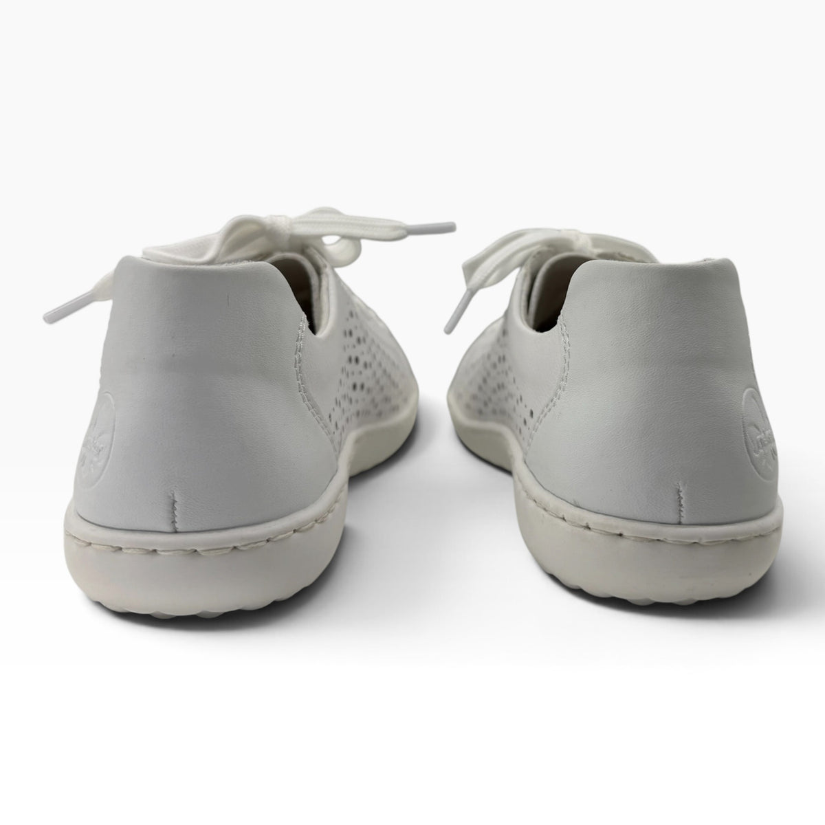 The Shoe Shop Dana white leather sneakers with laser-cut detailing, lace-up closure, and padded collars, rear view.