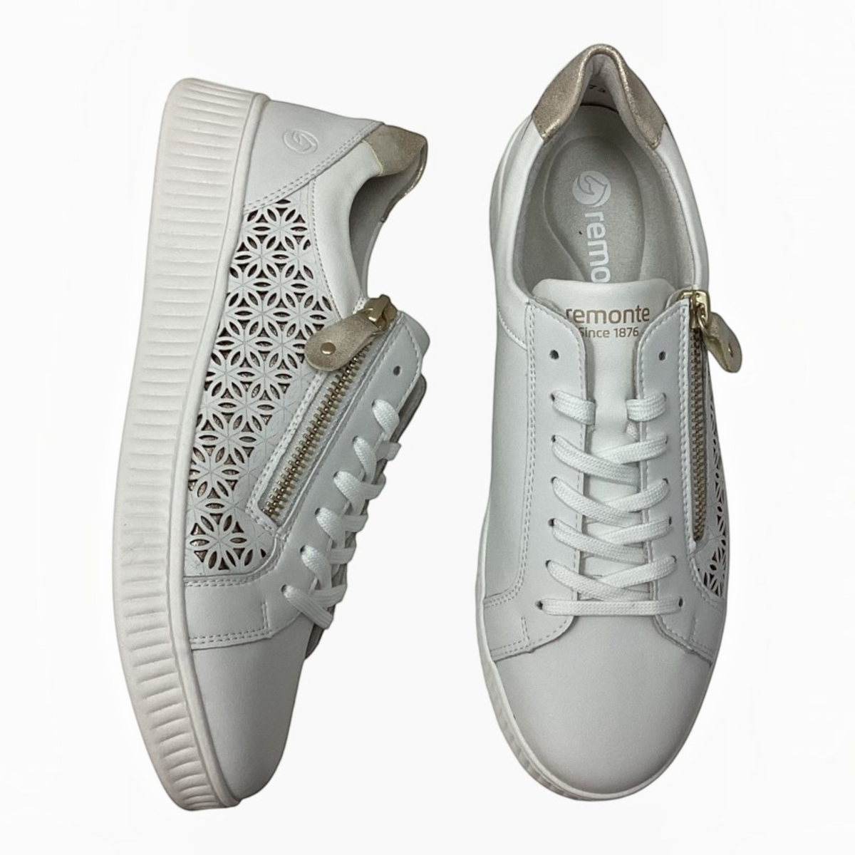 The Shoe Shop Dara white leather sneakers featuring laser-cut floral patterns, side zip closure, and metallic accents.