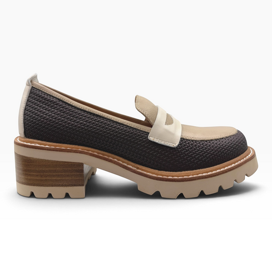 The Shoe Shop Delmira loafer featuring a dark textured upper, cream contrast panel, and a chunky block tread sole.