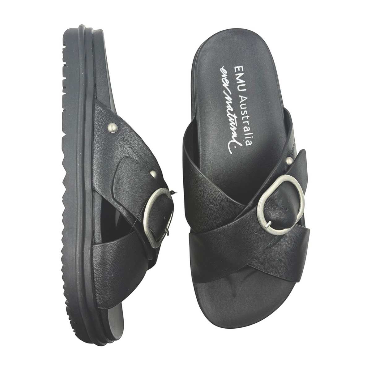 The Shoe Shop EMU Ebony black leather slide sandals with criss-cross straps and silver buckle detail.