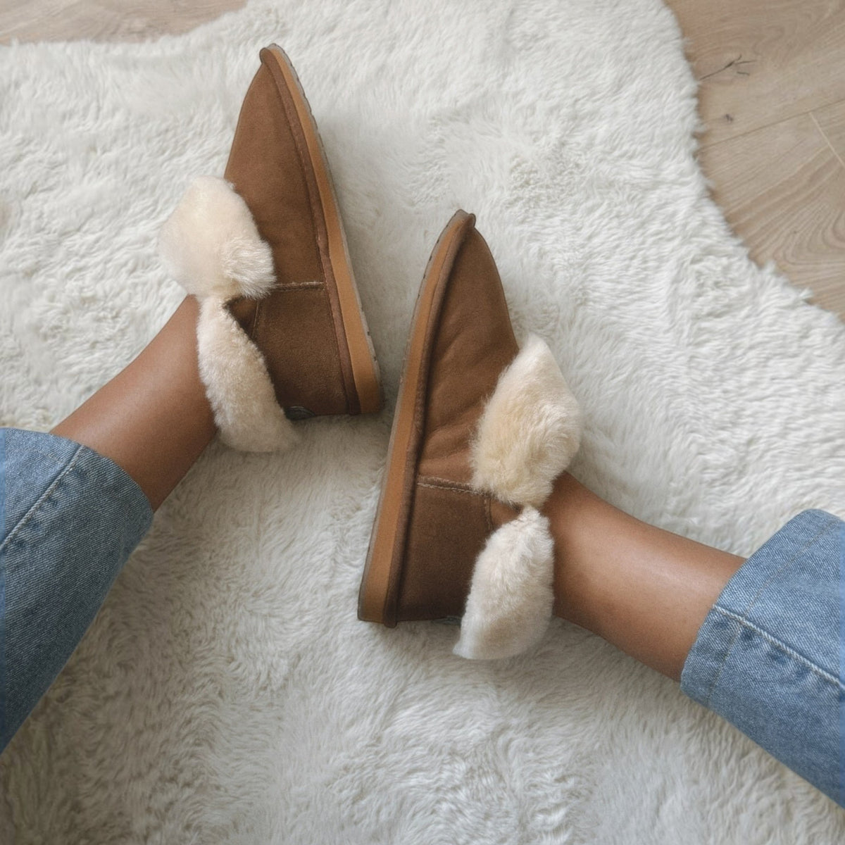 The Shoe Shop EMU Platinum Mintaro slippers in chestnut sheepskin with cream wool lining worn on a white rug