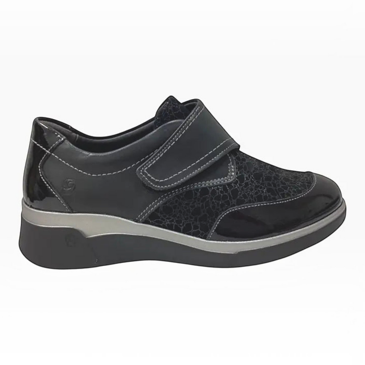 The Shoe Shop Ezra black leather shoe with patent detailing, Velcro strap, and a supportive low wedge sole.