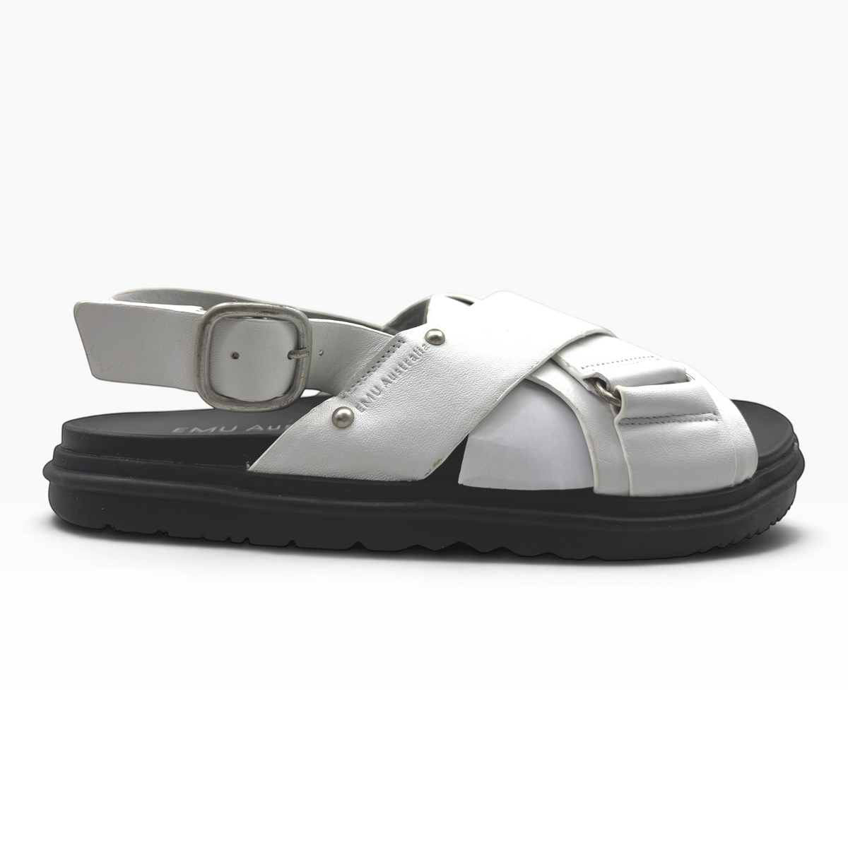 The Shoe Shop Faye white leather sandal with crossed straps, adjustable buckle, and a black ridged rubber sole.