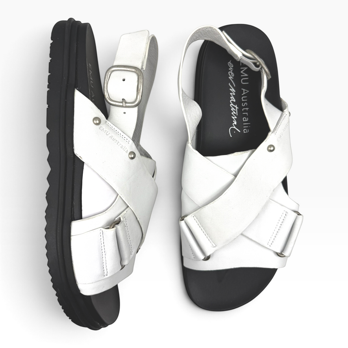 The Shoe Shop Faye white leather sandals with crossed straps, adjustable heel buckle, and black ridged rubber sole.
