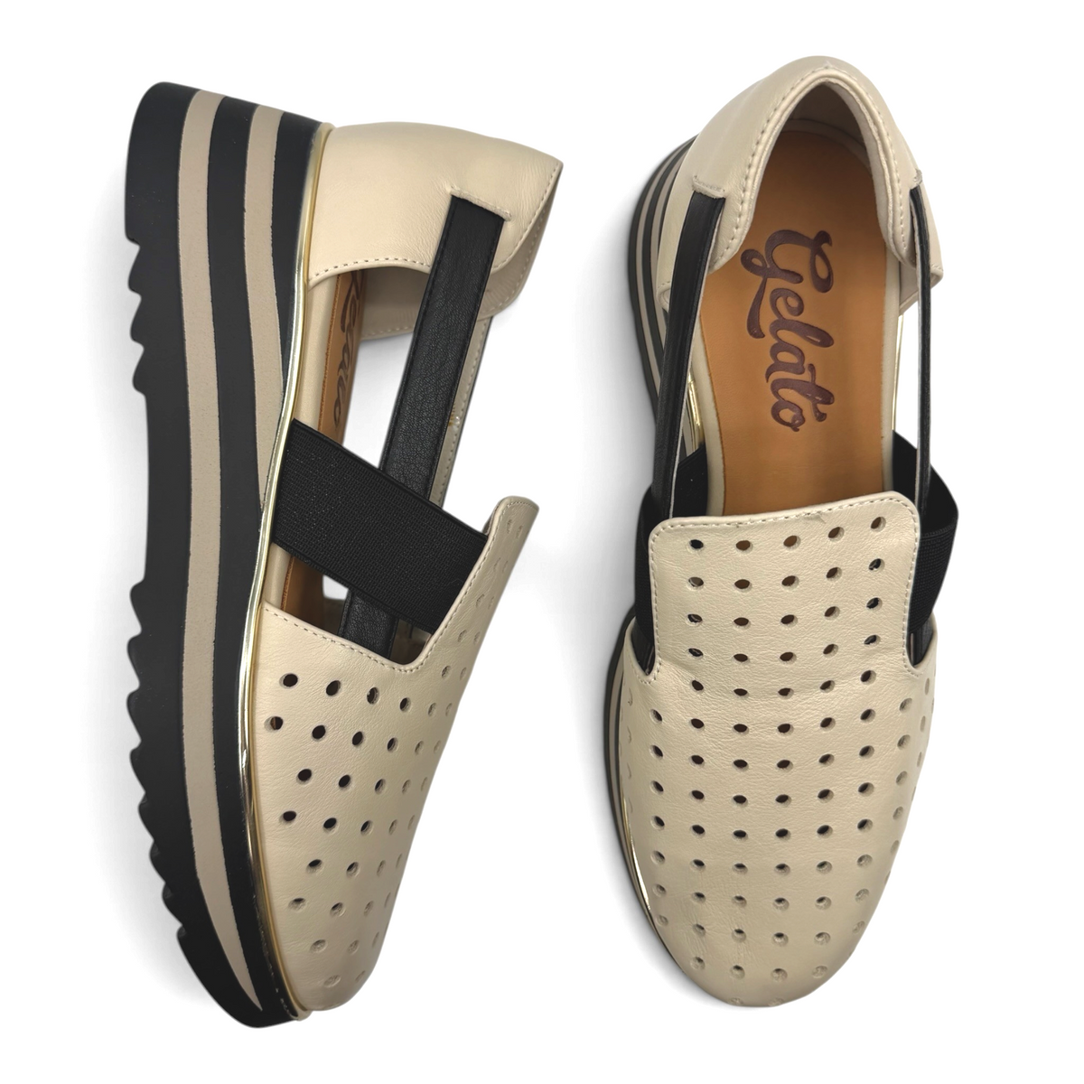 The Shoe Shop Gelato perforated beige slip-on flats with black elastic straps and striped platform soles.