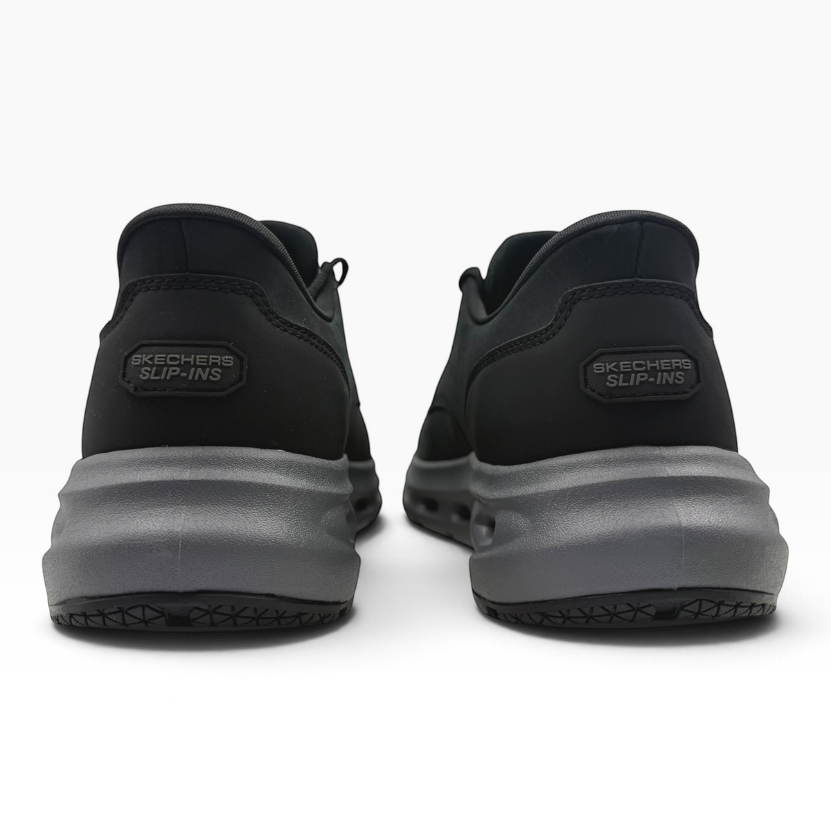 The Shoe Shop Glide Step Cade Ox black slip-in sneakers showing the heel and textured grey midsole from behind