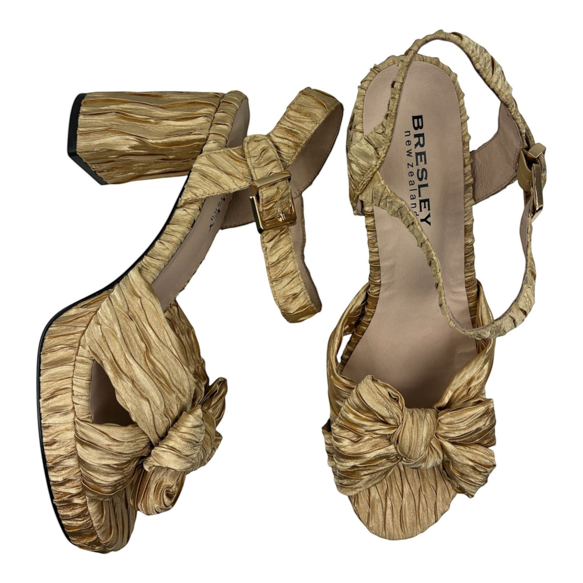 The Shoe Shop Sam gold metallic ruched block heel sandals with a knotted bow detail and adjustable ankle strap.