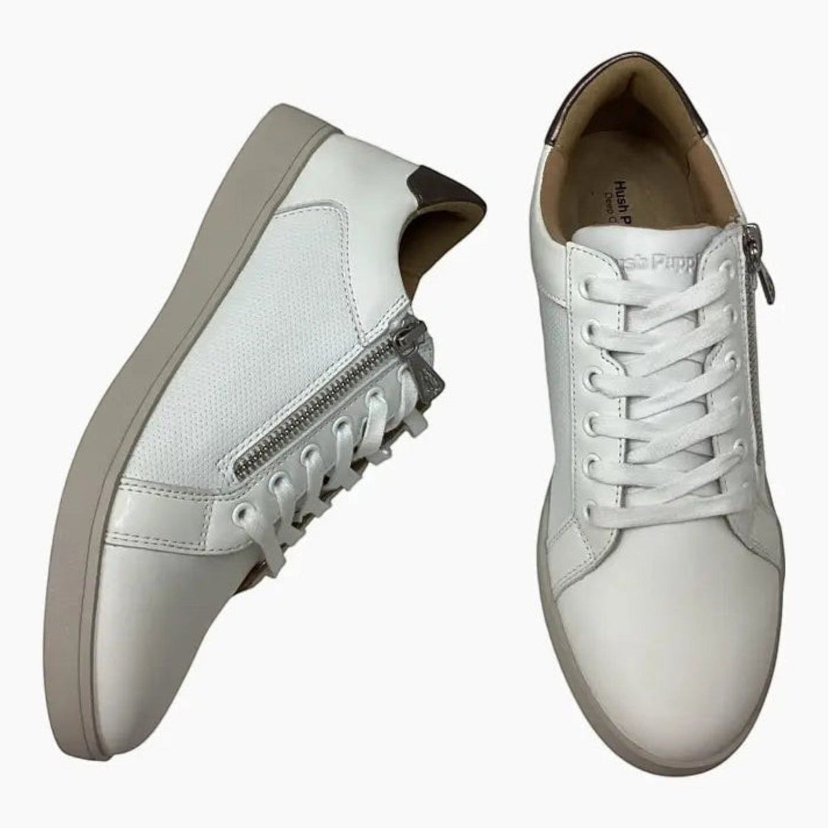 The Shoe Shop Hush Puppies Mimosa white leather sneakers with side zip, perforated panels, and gunmetal heel detail.