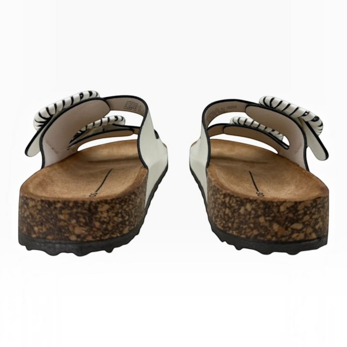 The Shoe Shop Jirona white leather slides with adjustable straps, statement buckles, and cork footbeds, rear view.