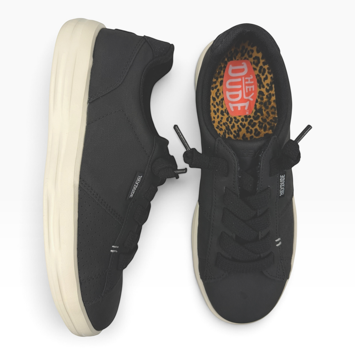 The Shoe Shop Karina Duo Classic black sneakers with a cream sole and leopard print interior lining.