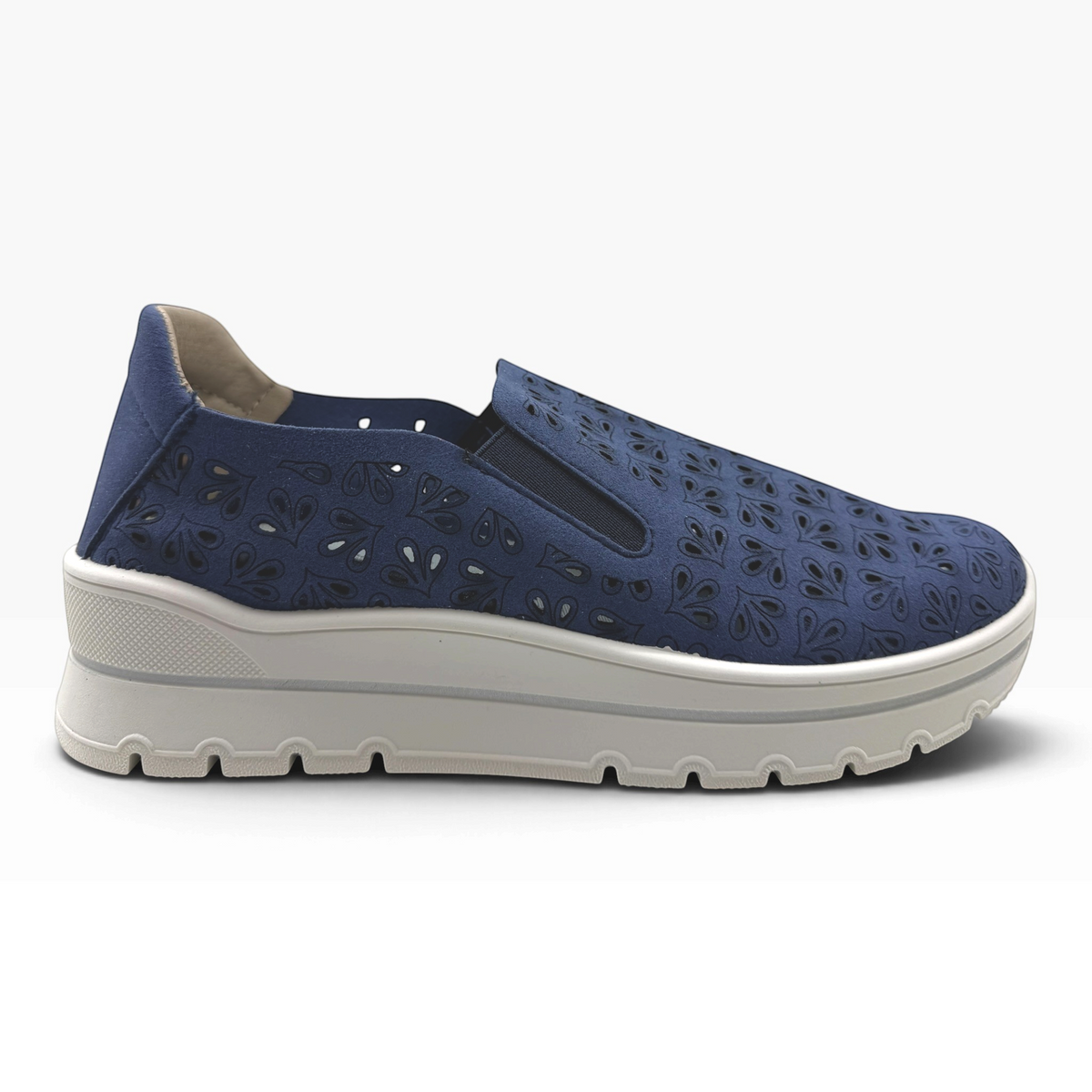 The Shoe Shop A40042 casual flat slip-on shoe in navy blue with laser-cut floral patterns and a thick white sole.
