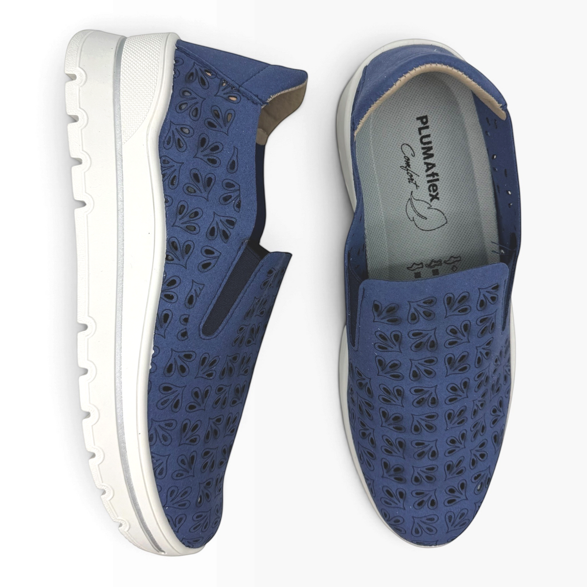 The Shoe Shop A40042 casual navy blue slip-on flats featuring a laser-cut floral pattern and white comfort soles.