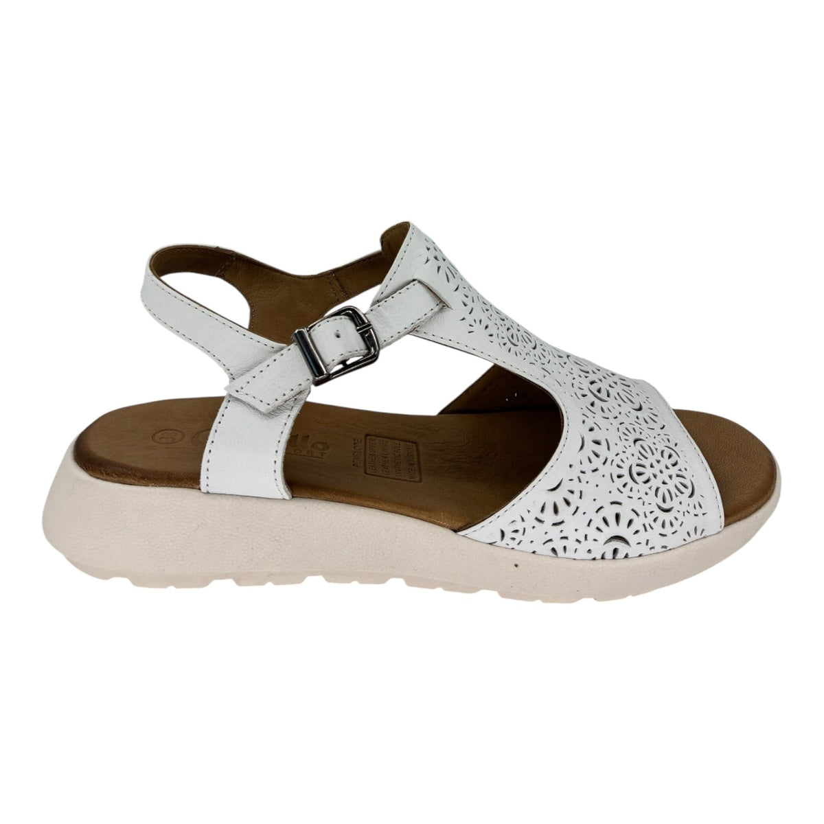 The Shoe Shop Penelope white leather sandal with laser-cut floral detailing, adjustable strap, and wedge heel.