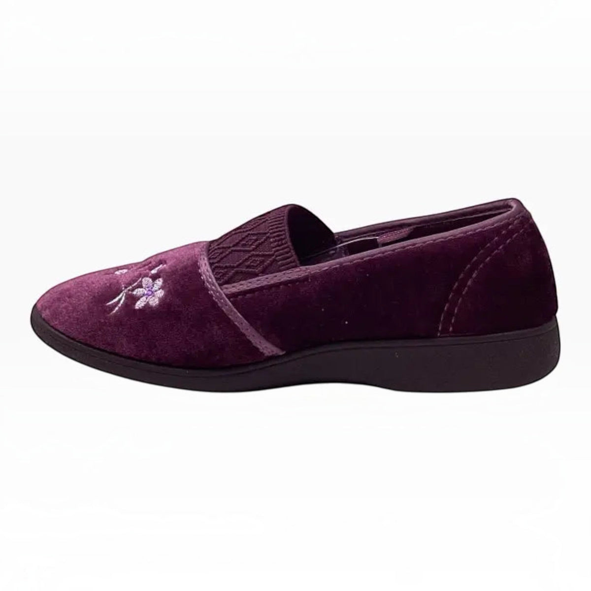 The Shoe Shop Sasha plush purple velvet slipper with floral embroidery and a low-profile black indoor sole.