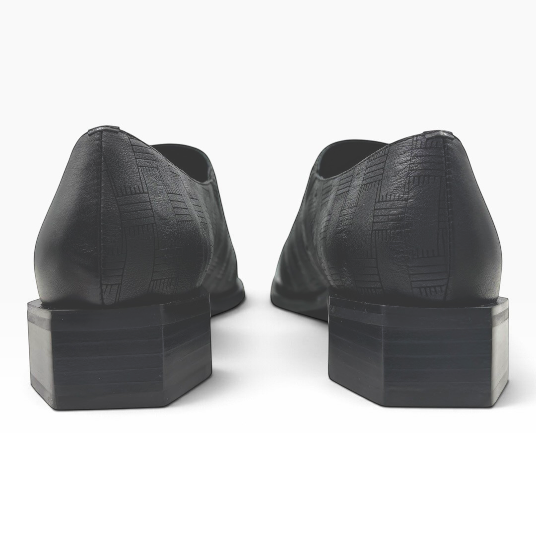 The Shoe Shop Romeo black textured leather loafers featuring a unique hexagonal heel, viewed from the back.