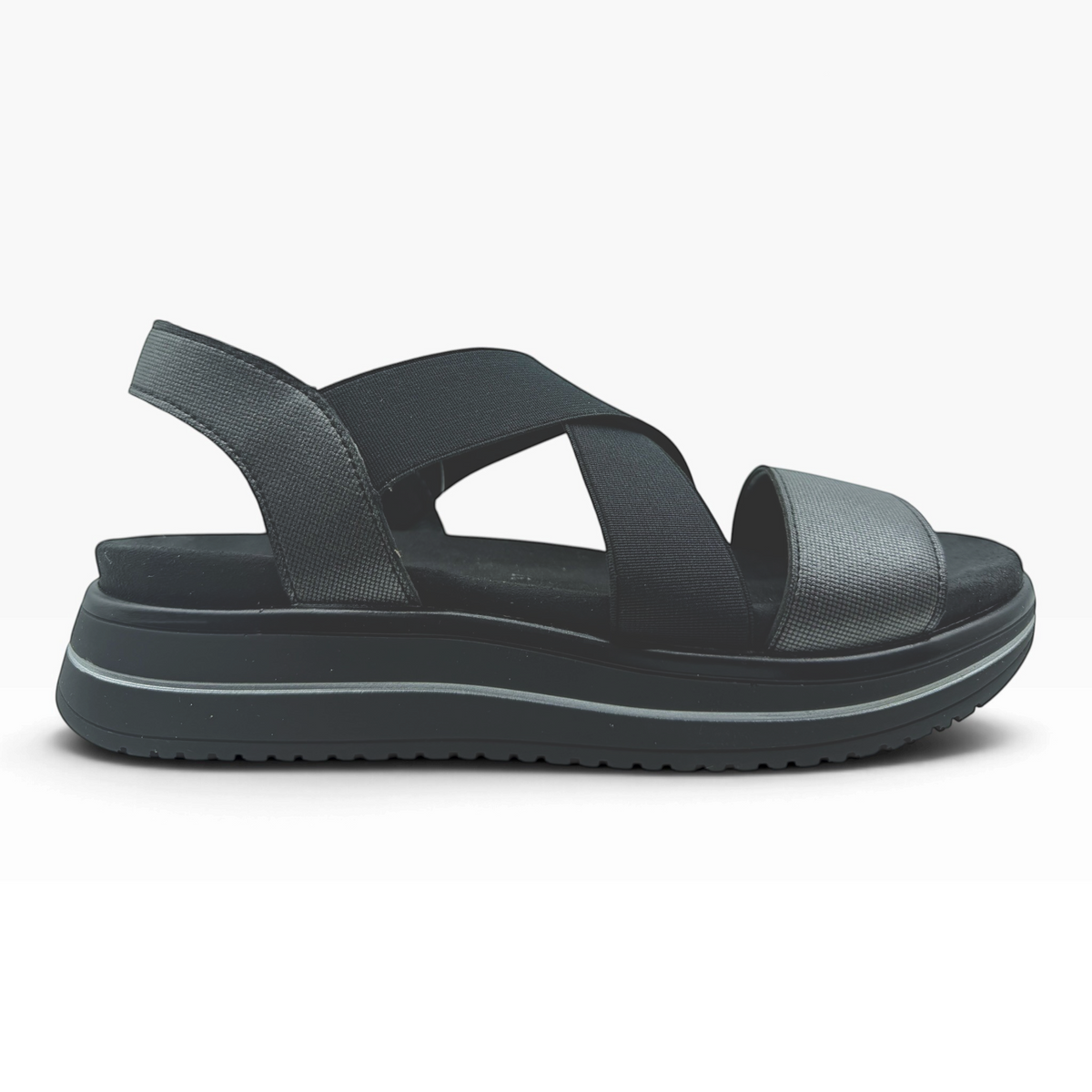 The Shoe Shop Sabrina black flatform sandal with elastic cross-straps, metallic front detail, and cushioned footbed.