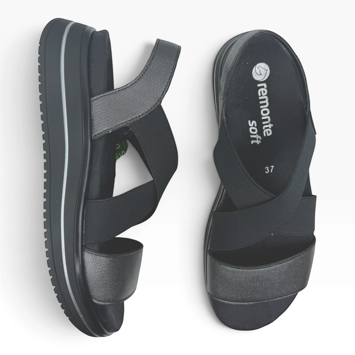 The Shoe Shop Sabrina black flatform sandals with elastic cross-straps, metallic-textured detail, and cushioned sole.