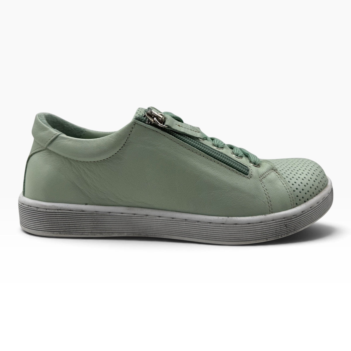 The Shoe Shop Tommie Perf sage green leather sneaker with perforated detailing, side zip, and white rubber sole.