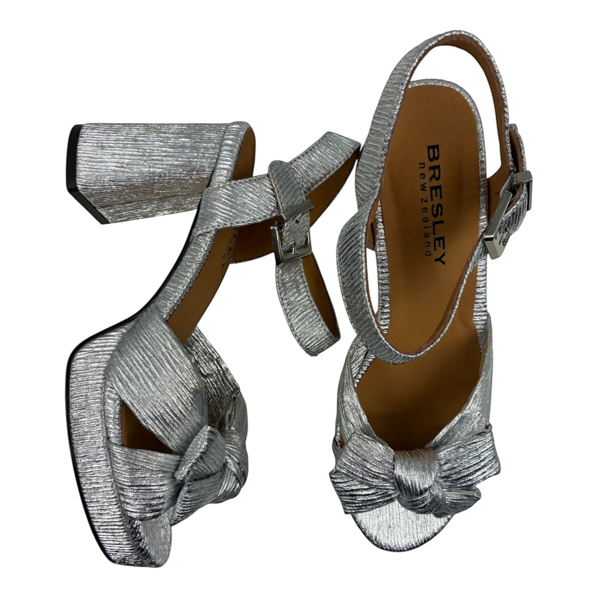 The Shoe Shop Sam silver metallic block heel sandals with a knotted bow detail and adjustable ankle strap.
