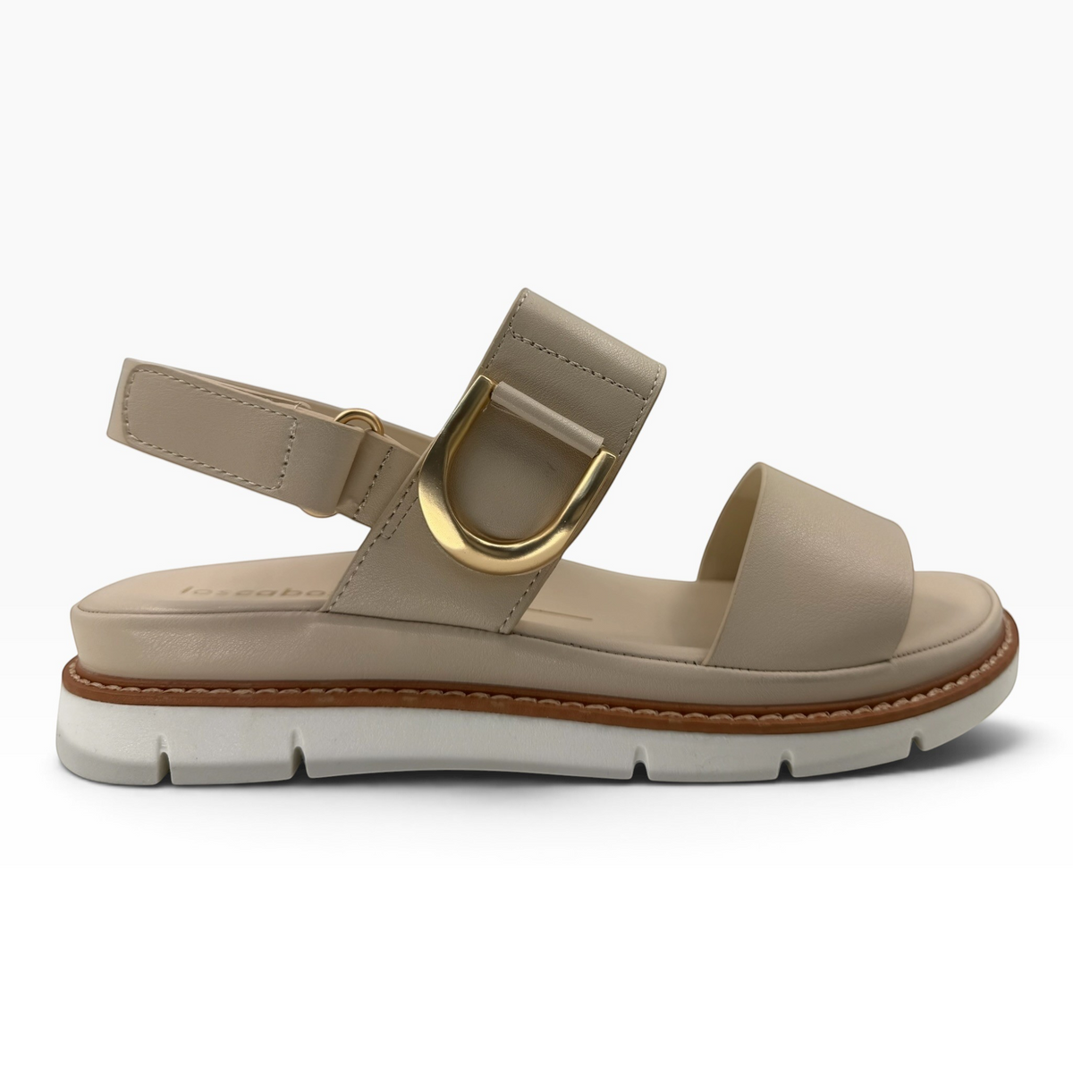The Shoe Shop Sana leather wedge sandal in beige with a gold-tone D-buckle, slingback strap, and lugged white outsole.