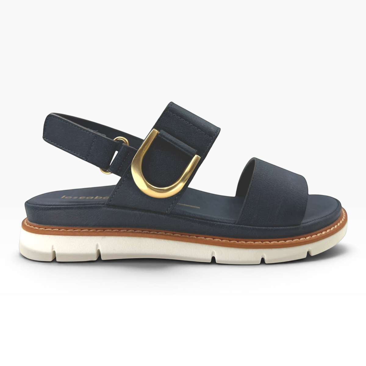 The Shoe Shop Sana navy leather wedge sandal with a gold-tone D-buckle, slingback strap, and white lugged outsole.