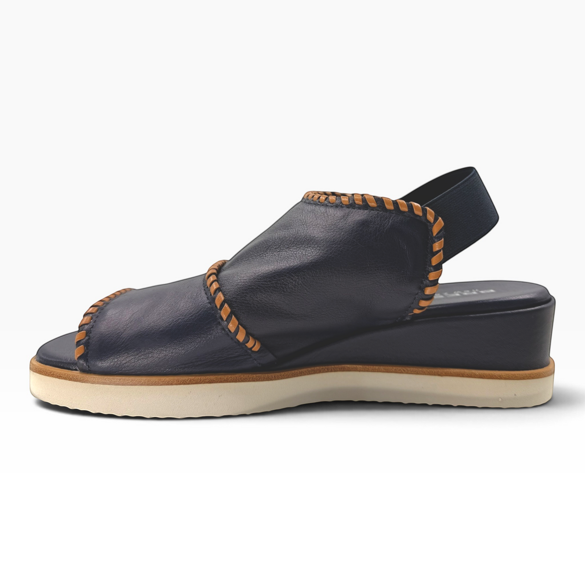The Shoe Shop Sigma navy leather wedge sandal with contrast tan whipstitching and an elasticated slingback strap.