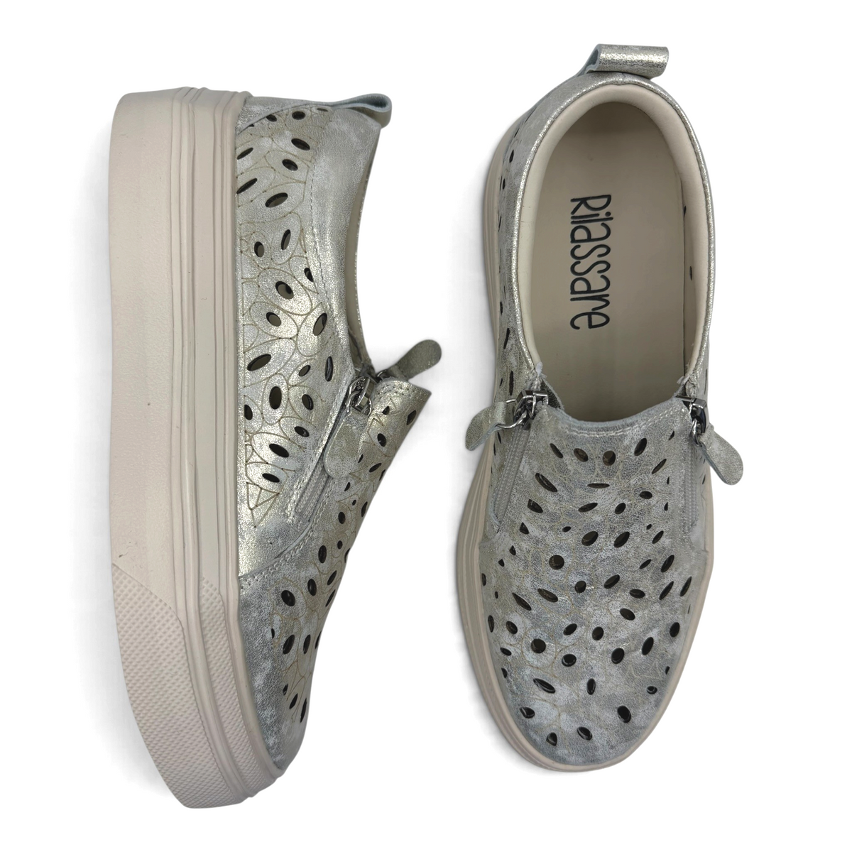 The Shoe Shop Triffic silver leather sneakers with laser-cut floral patterns, side zips, and platform rubber soles.