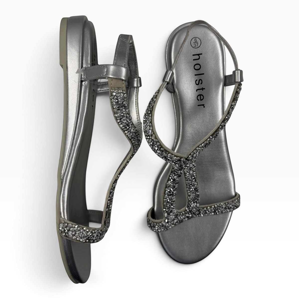 The Shoe Shop Strut low wedge sandals in metallic silver with shimmering rhinestone trim and a comfortable slingback.