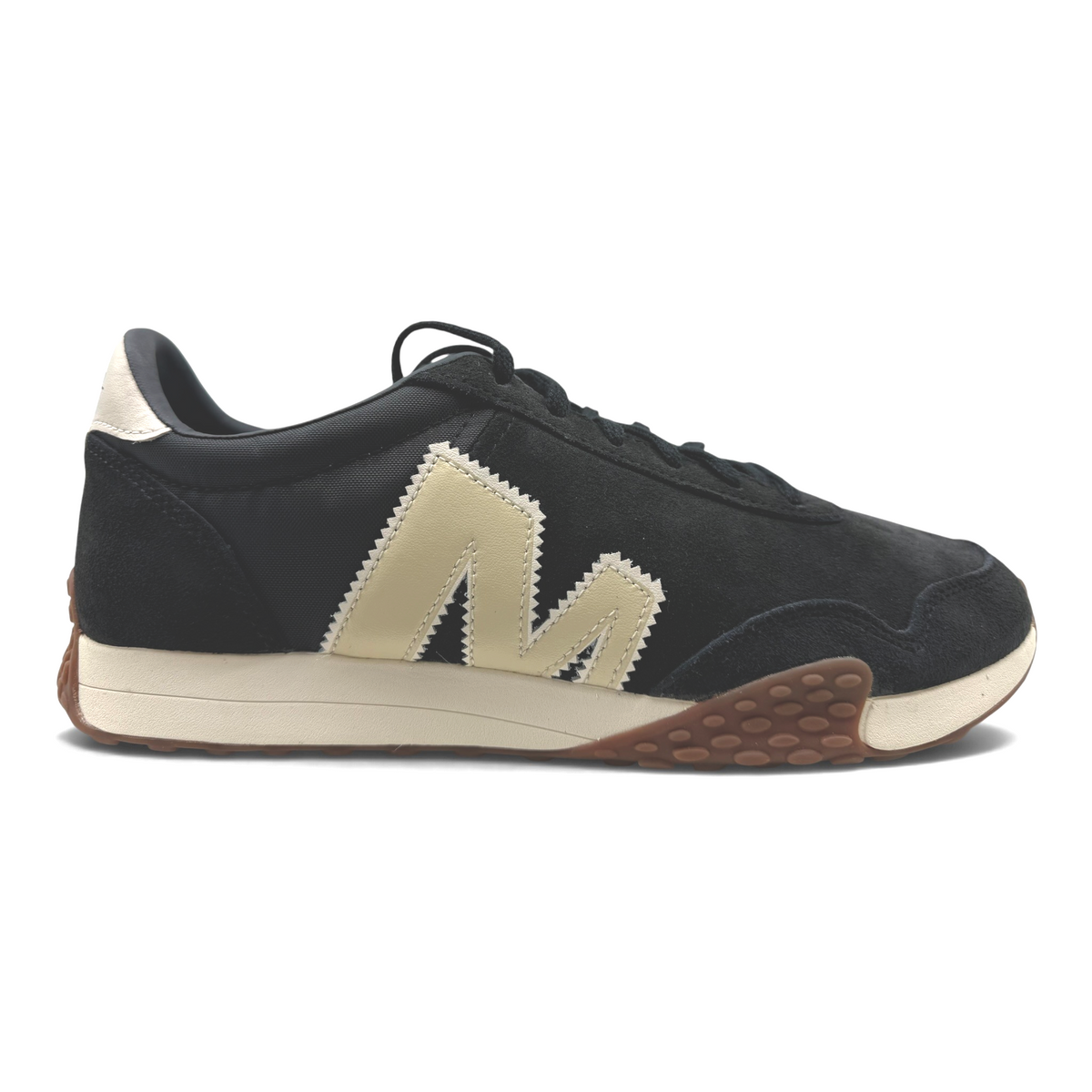 The Shoe Shop Sprint Anthem sneaker in black suede and mesh with a cream logo, white midsole, and gum-rubber outsole.