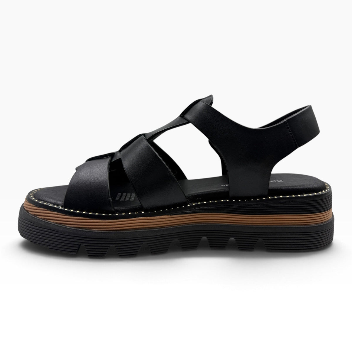 The Shoe Shop Sylvera black leather platform sandal with wide cross-straps, chunky ridged sole, and tan welt detail.