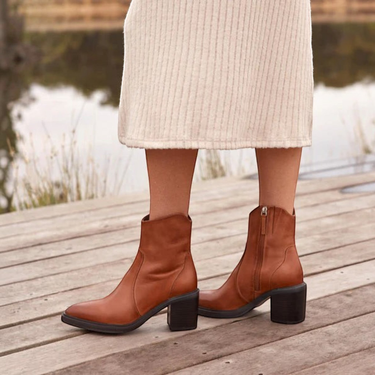The Shoe Shop Janice tan leather Western-inspired ankle boots with a pointed toe and 70mm block heel on a wooden deck.