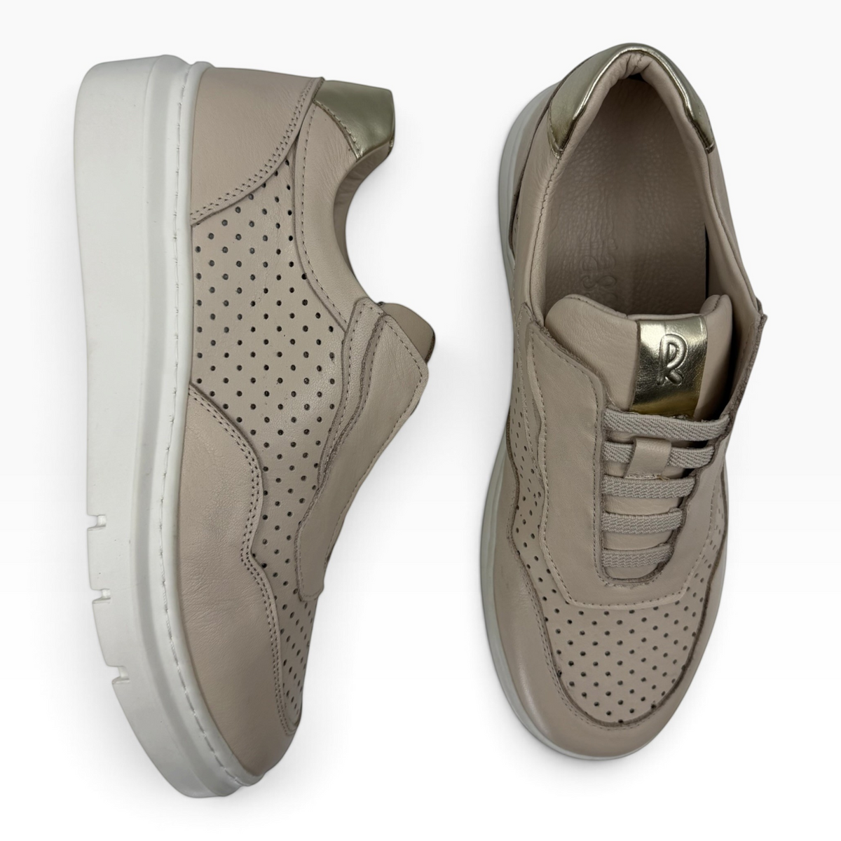 The Shoe Shop Taurus Sneak beige leather sneakers with perforated detailing and metallic gold heel and tongue accents.