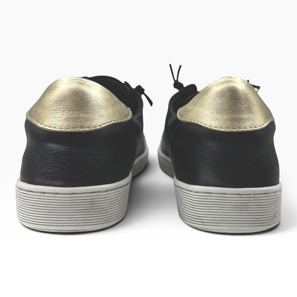 The Shoe Shop Rilassare Temi black leather sneakers with metallic gold heel detail, viewed from the back.
