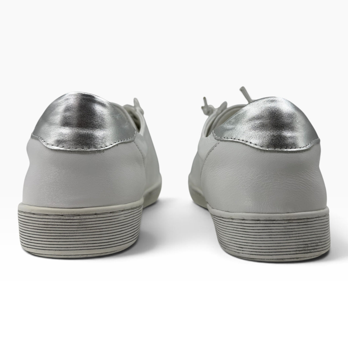 The Shoe Shop Temi white leather sneakers with metallic silver heel detail, viewed from the back.