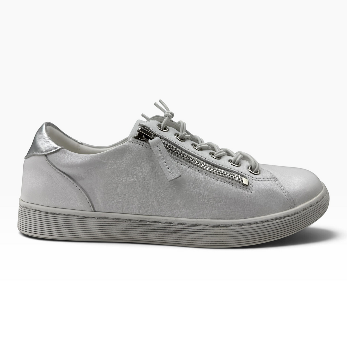 The Shoe Shop Temi white leather sneaker featuring a side zip, elastic laces, and metallic silver heel detail.