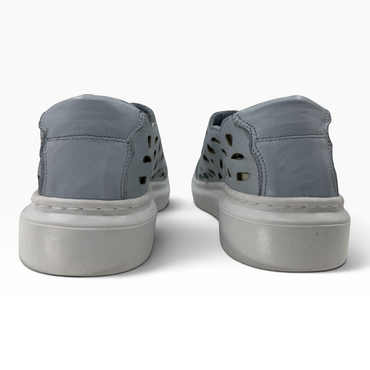 The Shoe Shop Tira sneaker in light blue leather with laser-cut detailing and a thick white rubber sole, back view.