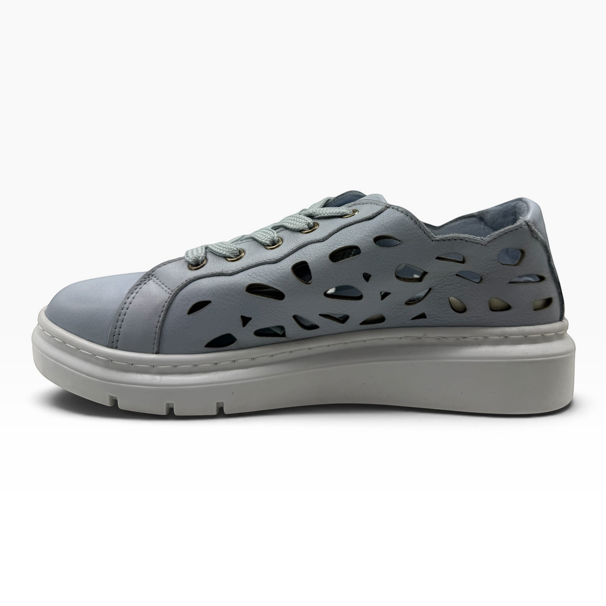 The Shoe Shop Tira sneaker in light grey leather with decorative laser-cut side panels and a thick white rubber sole.