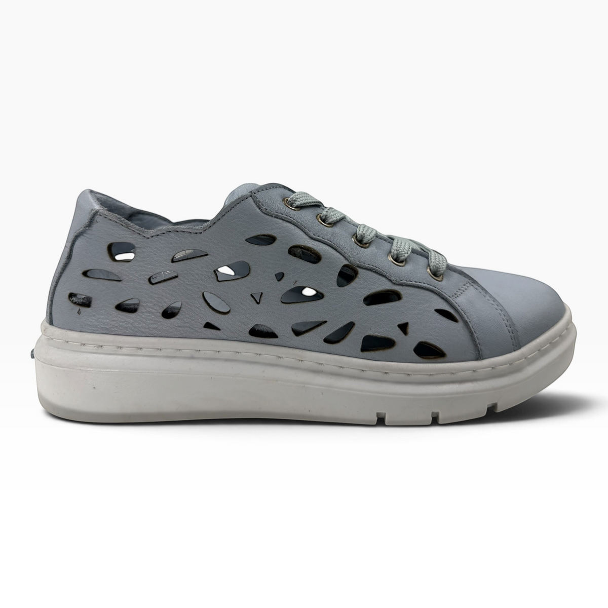 The Shoe Shop Tira Sneak in light grey leather with decorative laser-cut side panels and a thick white rubber sole.