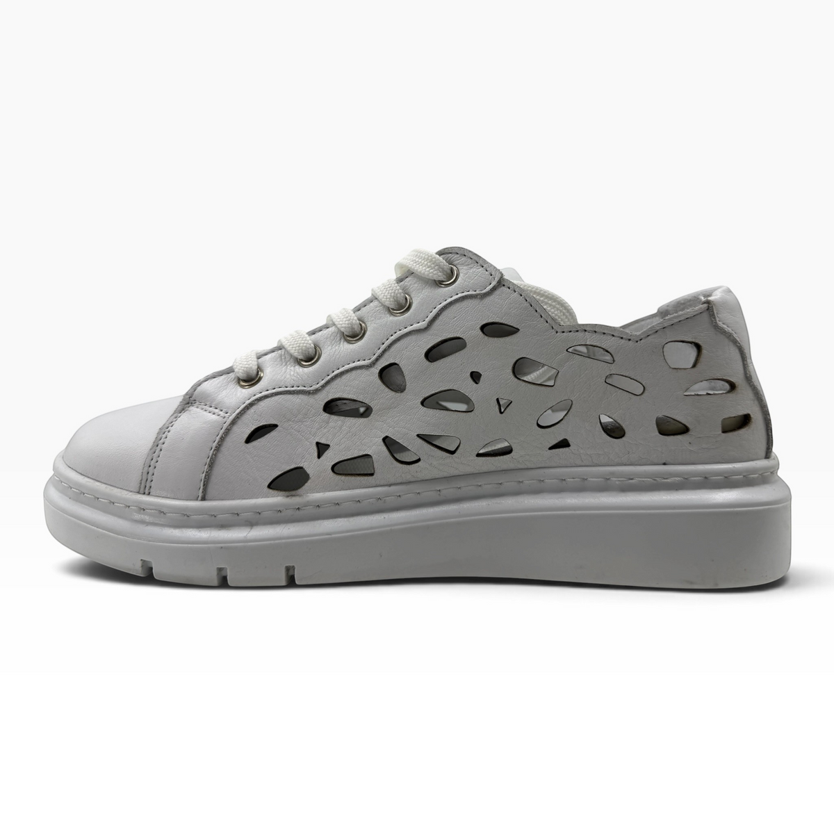The Shoe Shop Tira white leather sneakers featuring a stylish laser-cut floral pattern and a thick platform sole.